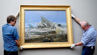 Zwei Mitarbeiter der Alten Nationalgalerie hängen das Gemälde "Das Eismeer" von Caspar David Friedrich an die Wand des Museums, Foto: dpa/Alina Schmidt