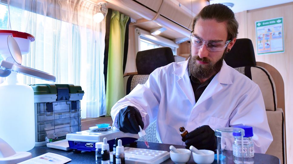 Felix Blei vom Kooperationspartner "miraculix" aus Jena zeigt ein Testverfahren für das Drug Checking im mobilen Labor; © dpa-Zentralbild/Martin Schutt